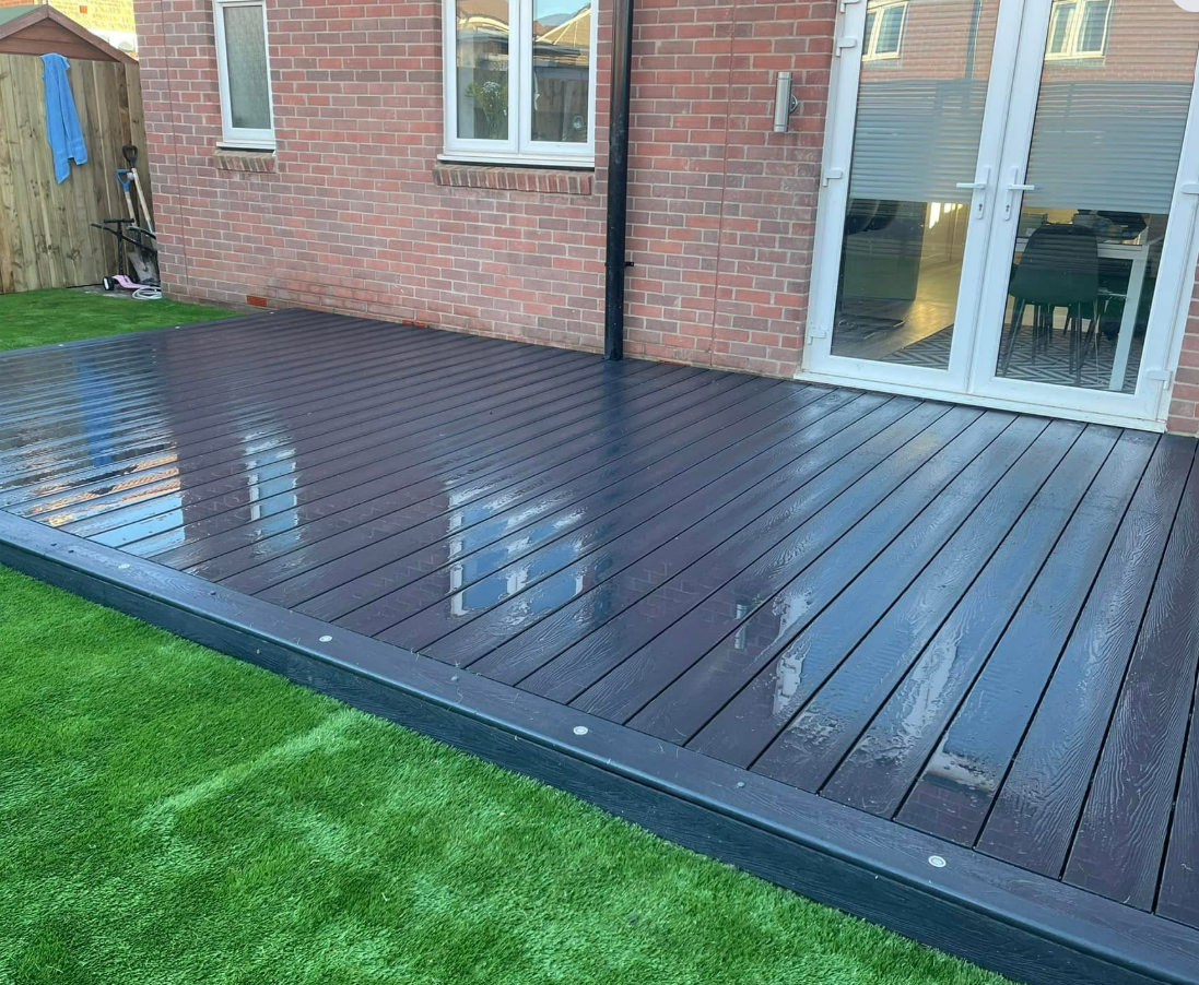 Dark premium decking beside family lawn